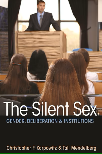 group of women in focus listening to a man at lectern out of focus
